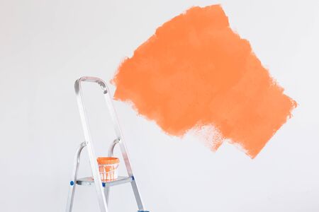 Ladder with paint in bucket near color wall indoors. Renovation and redecoration.の写真素材