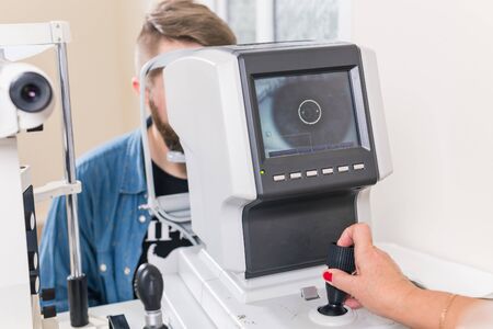 Medicine, ophthalmology concept - patient checks her vision by an ophthalmologist.の写真素材
