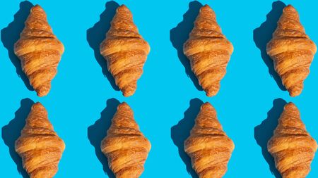 Bakery products pattern with baked croissant. Blue background, top view. Pop art style. Delicious and food.の写真素材