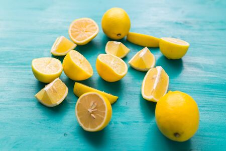 Freshly cut half and whole lemons on rustic aquamarine colour boards. Summer, vitamins and...
