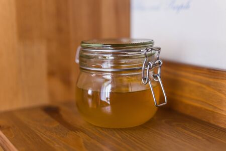 Honey jar standing on the shelf at home. Sweet and dessert.の写真素材