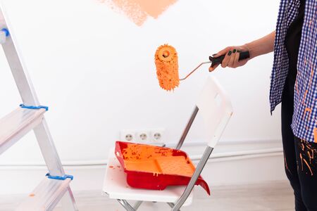 Repair in the apartment. Happy middle-aged paints the wall with paintの写真素材