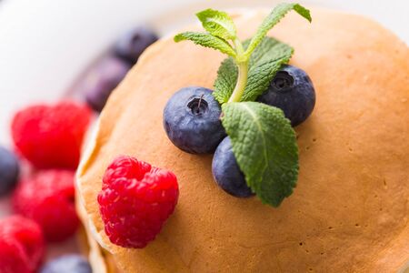 Homemade american pancakes with fresh blueberry and raspberries. Healthy morning breakfast. Rustic style.の写真素材