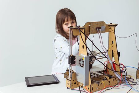 Little child architect using 3D Printer. Schoolgirl, technologies and study concept.の写真素材