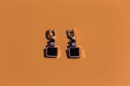 Womens Jewelry. Trendy jewelry on dark yellow background. Flat lay, top view.