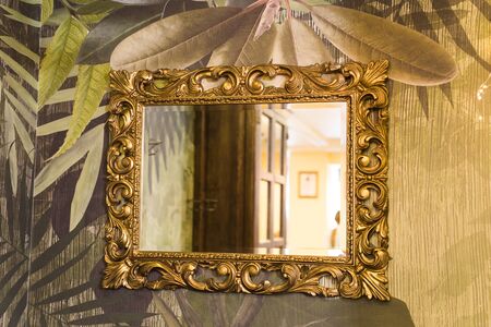 Luxury vintage mirror with gold frame on the wall. Isolated insideの写真素材