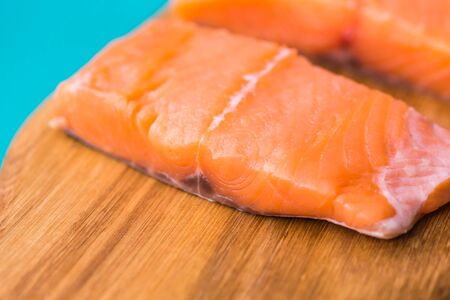 Fresh raw salmon on wooden cutting board.