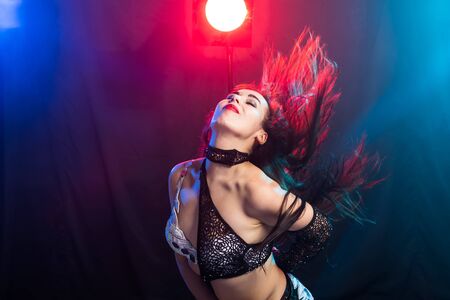 Young woman belly dancer in exotic dress with gold, dancing tribal fusion dance in studio.の写真素材