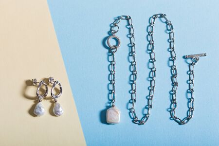 Women's Jewelry. Trendy jewelry on coloured background. Flat lay.
