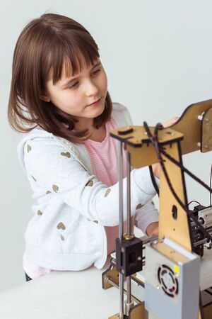 Child student makes the item on the 3D printer. School, technologies and science concept.