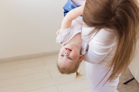 Young mother playing with her baby girl at home. Motherhood, infant and children.の写真素材