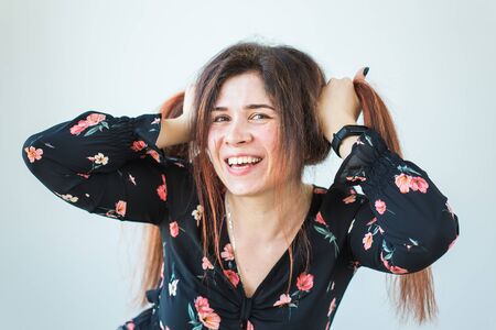 Playful and happy funny redhead woman having fun laughing on a white background.の写真素材