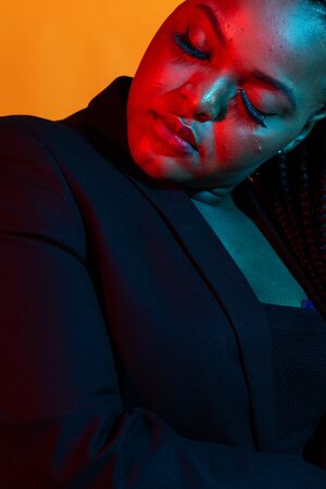 Portrait of beautiful african american female model posing. Colourful light.の写真素材