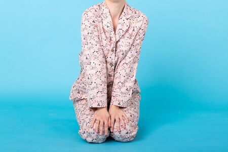 Close up of girl in home wear pajama having fun over blue background. Relax good mood, lifestyle and sleepwear concept.の写真素材