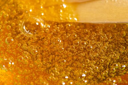 Liquid yellow paste for sugaring on blue background. Hair removal and depilation.の写真素材