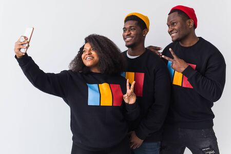 Friendship and fun concept - Group of friends afro american men and woman taking selfie in studio on white background.の写真素材