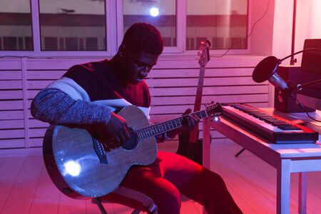 Create music and a recording studio concept - Bearded man guitarist recording electric guitar track...