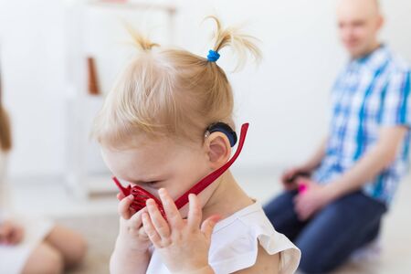 Baby girl wearing a hearing aid. Disabled child, disability and deafness.の写真素材
