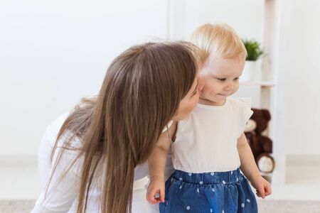 Young mother playing with her baby girl at home. Motherhood, infant and children concept.の写真素材