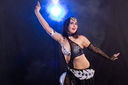 Spirituality dance. Beautiful sexy woman with luxury glossy eastern make-up dancing tribal fusion. Belly dance.の写真素材