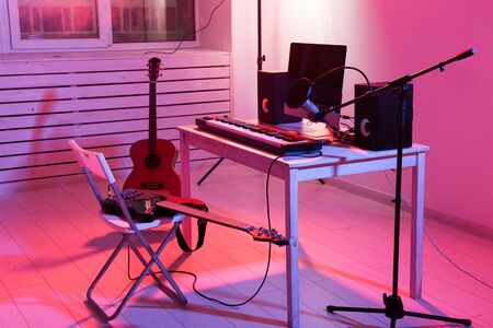 Microphone, computer and musical equipment guitars and piano background. Home recording studio concept.の写真素材