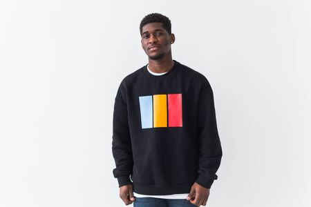 Portrait handsome young black man dressed in jeans and sweatshirt on white background. Street fashion and modern youth culture.の写真素材