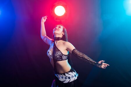 Young woman belly dancer in exotic dress with gold, dancing tribal fusion dance in studio.の写真素材