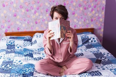 Close-up of woman wears pajama and relaxing at home and reading a book. Stay home. Quarantine...