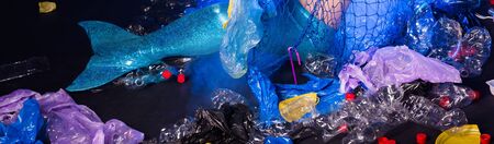 Ocean pollution, rubbish in the water. Close-up of fairytale mermaid in dirty ocean. Plastic trash and garbage in water. Environmental problem, plastic bag and bottles polluting planet.の写真素材