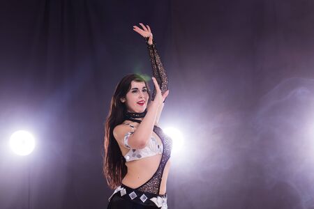 Belly dancer. Young attractive woman dancing tribal fusion on the stage. Oriental exotic dance. Copy space.の写真素材