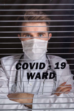 Medicine and health care concept. Man doctor in hospital. Doctor wearing protective mask checking...