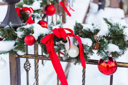Christmas cityscape - decorating railing porch on the eve of the holiday. Christmas baubles and tapes. Winter holidays.の写真素材