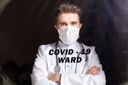 Medicine and health care concept. Man doctor in hospital. Doctor wearing protective mask checking and take care infected people from covid-19.の写真素材