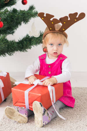 Baby holding Christmas gift. Winter holidays concept.の写真素材