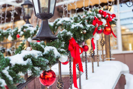 Christmas cityscape - decorating railing porch on the eve of the holiday. Christmas baubles and tapes. Winter holidays.の写真素材