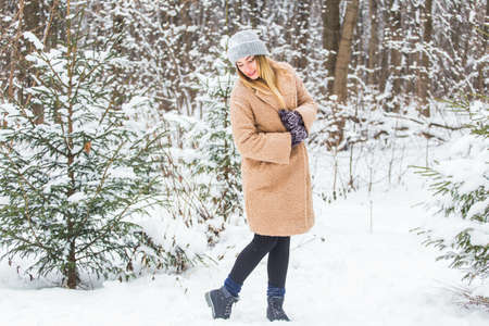 Beautiful winter portrait of young woman in the winter snowy scenery