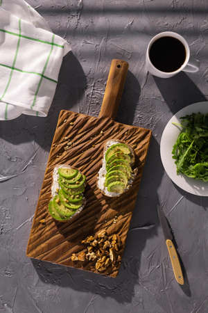 Sliced avocado on toast bread with nuts. Breakfast and healthy food concept.