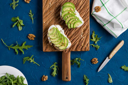 Sliced avocado on toast bread with nuts. Breakfast and healthy food concept.