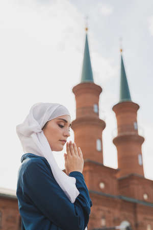 Muslim woman prayer wear hijab fasting pray to allah on mosque backgroundの写真素材