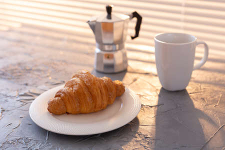 Breakfast with croissant and moka pot. Morning meal and breakfast concept.