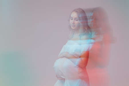 Pregnant woman in white long dress in fantasy style picture.の写真素材