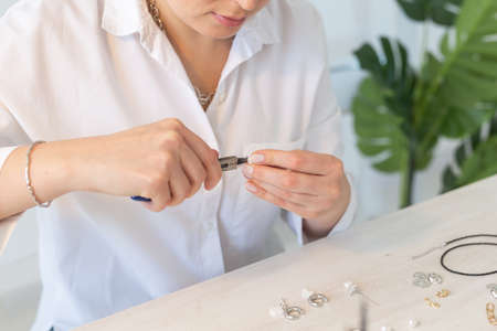 Professional jewelry designer making handmade jewelry in studio workshop close up. Fashion, creativity and handmade conceptの写真素材