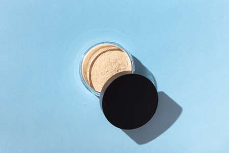Mineral powder foundation isolated on blue background. Eco-friendly and organic beauty productsの写真素材