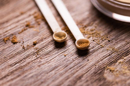 Mineral powder with a spoon dispenser for make-up on wooden backgroundの写真素材
