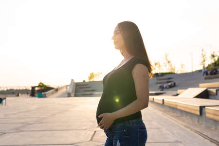 Hispanic pregnant woman relaxing and enjoying life outdoor. Pregnancy and motherhood concept.の写真素材