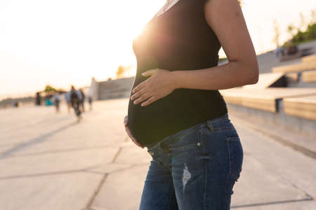 Close-up of pregnant belly outdoors copyspace. Pregnancy and motherhood concept.の写真素材