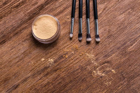 Mineral powder foundation with brushes on a wooden background with copy space. Eco-friendly and...