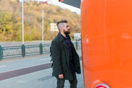 Portrait of man choosing fast food in food truck in the street. Meal, food industry and streetfood concept.の写真素材