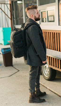 Portrait of man choosing fast food in food truck in the street. Meal, food industry and streetfood...