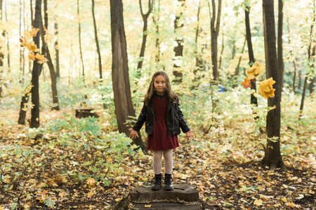 Asian child girl laughing and playing in the autumn on the nature walk outdoorsの写真素材